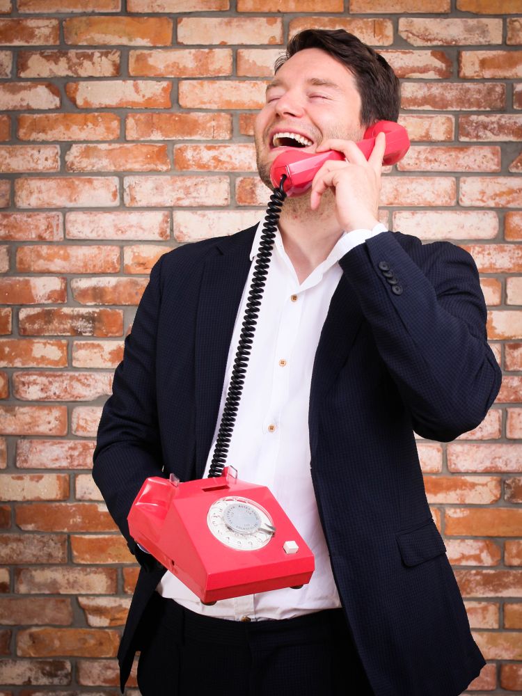 Ein junger Mann spricht lachend in ein Audio-Gästebuch von Quasselstrippe Ein junger Mann spricht lachend in ein Audio-Gästebuch von Quasselstrippe